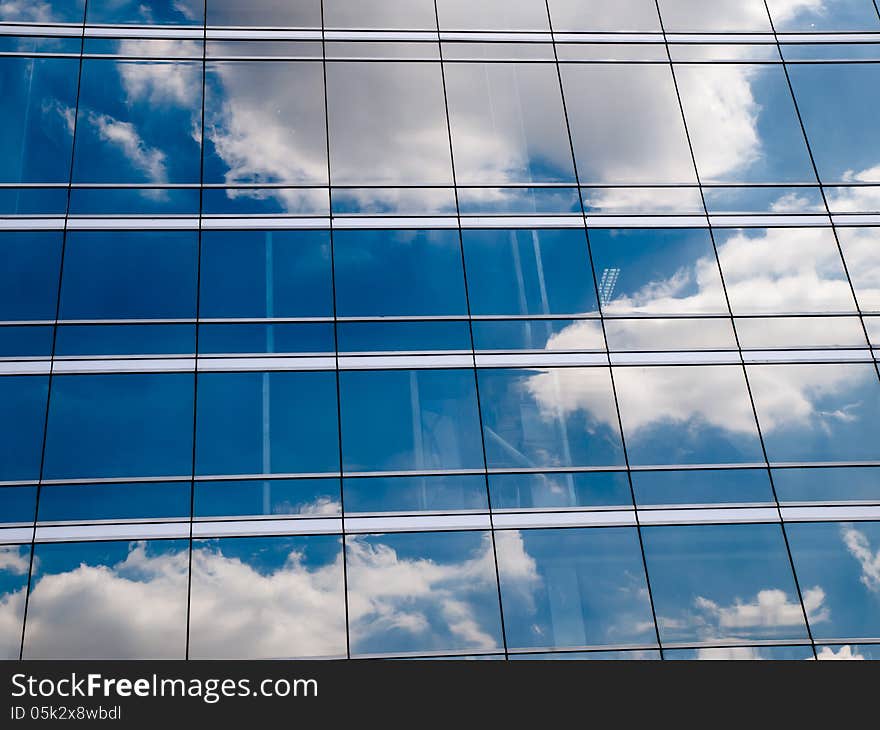 Clouds reflected in windows of modern office building