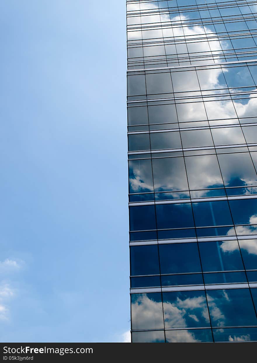 Clouds reflected in windows of modern office building