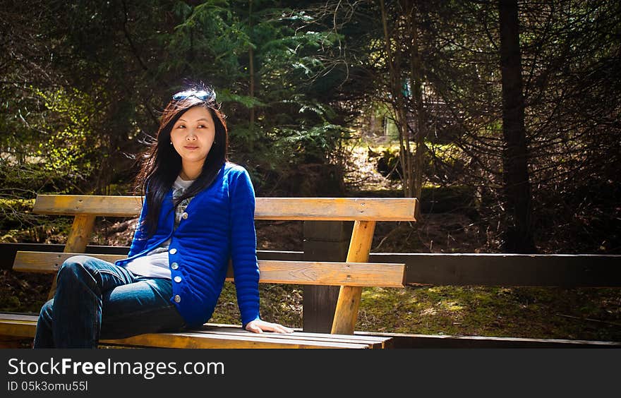 Young Girl Look Aside When Sitting On Bench