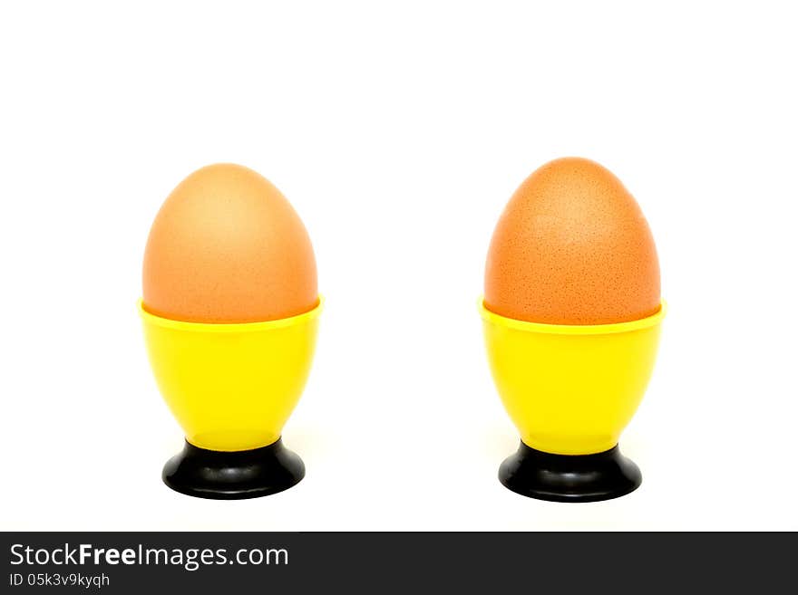 Eggs in a yellow cup on a white background. Horizontal position. Eggs in a yellow cup on a white background. Horizontal position.