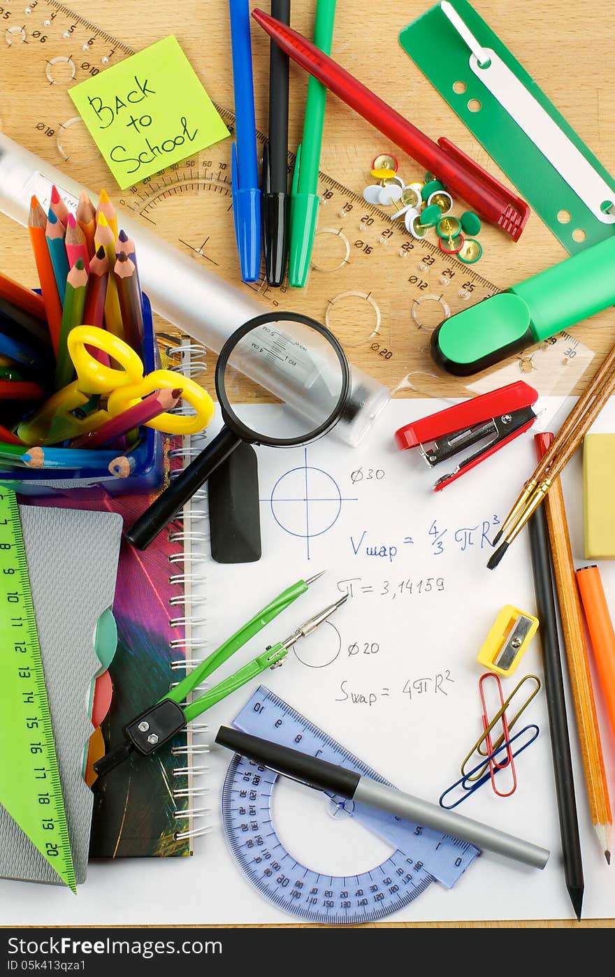 School Supplies with Note Pads, Pencils, Pens, Colored Pencils, Scissors, Pencil Sharpener, Buttons, Drawing Compass, Magnifier, Stapler, Slide-Rule and Ruler Lines on School Desk . Top View