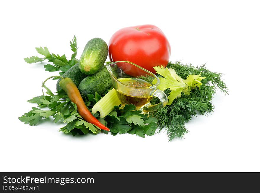 Arrangement of Ripe Tomato, Cucumbers, Chili Pepper, Parsley, Dill, Celery and Glass Gravy Boat with Olive Oil and Spices isolated on white background. Arrangement of Ripe Tomato, Cucumbers, Chili Pepper, Parsley, Dill, Celery and Glass Gravy Boat with Olive Oil and Spices isolated on white background