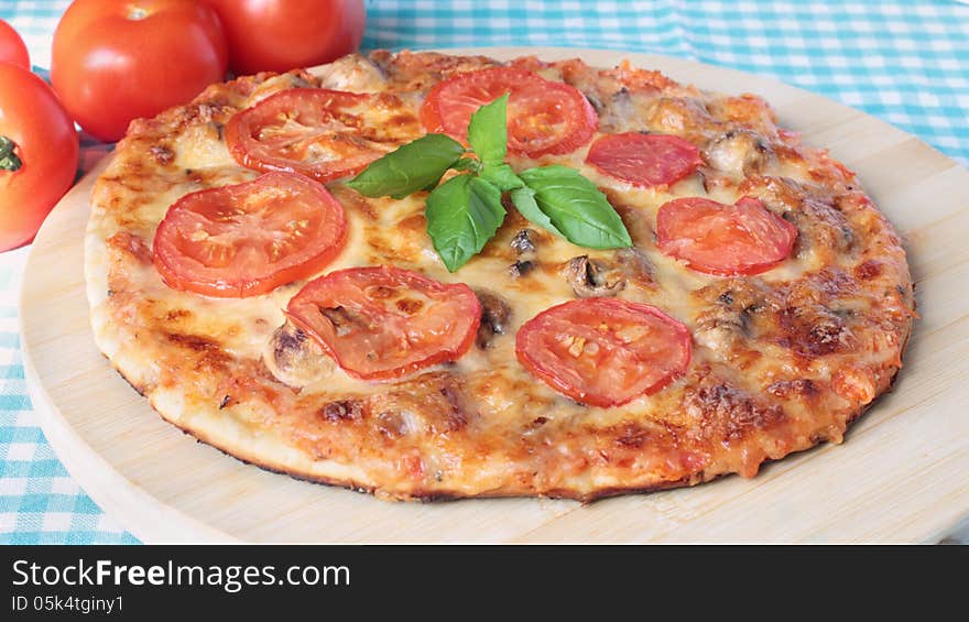 Homemade vegetarian pizza with cheese, tomatoes and mushrooms on a wooden board. Homemade vegetarian pizza with cheese, tomatoes and mushrooms on a wooden board