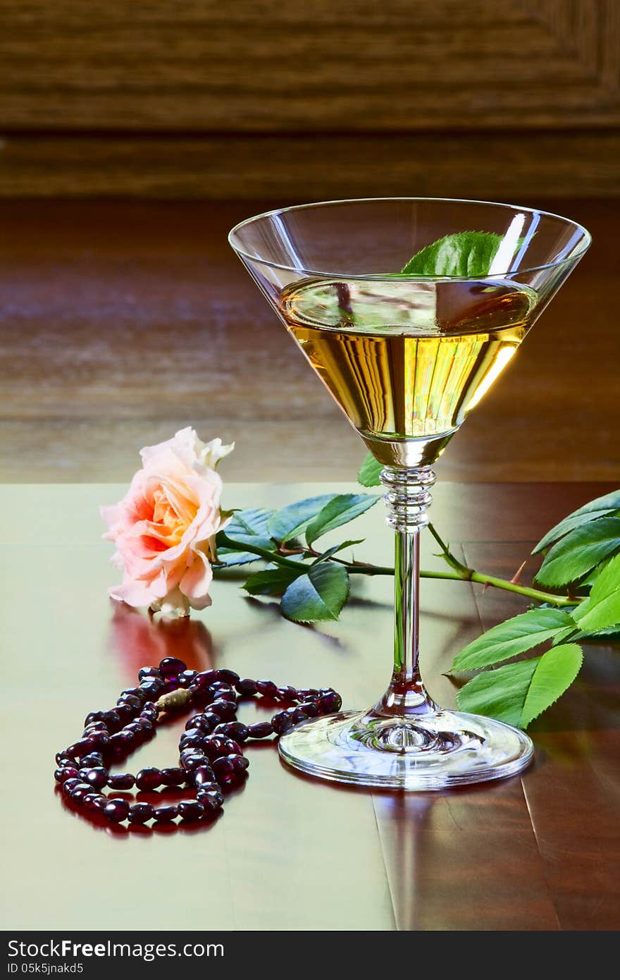 Garnet necklace, glass with white wine and a rose on an old table. Garnet necklace, glass with white wine and a rose on an old table