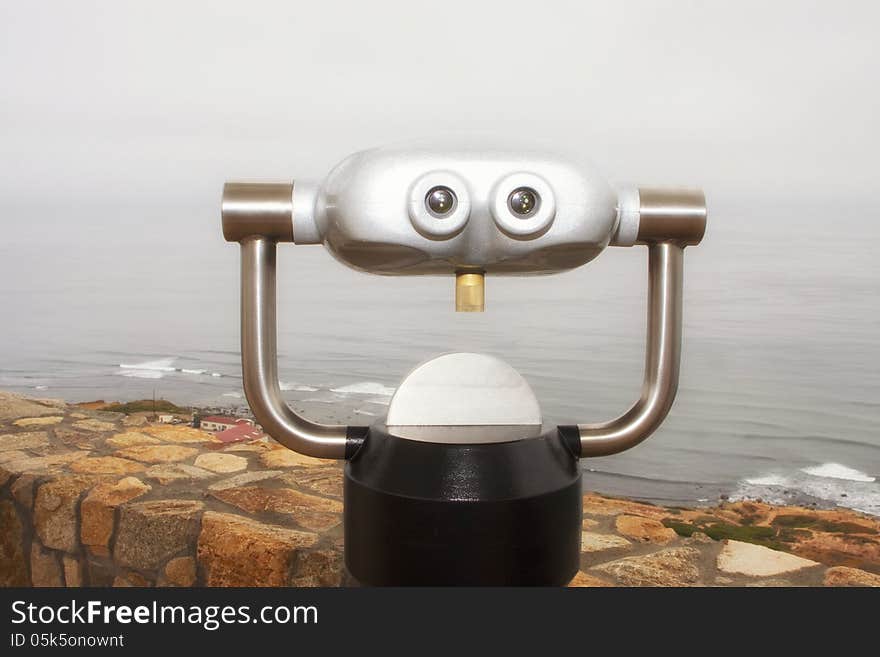 A futuristic looking alien styled travelers binocular magnifying scope vendor device shows through the fog overlooking the Pacific Ocean near San Diego, California, United States. A futuristic looking alien styled travelers binocular magnifying scope vendor device shows through the fog overlooking the Pacific Ocean near San Diego, California, United States