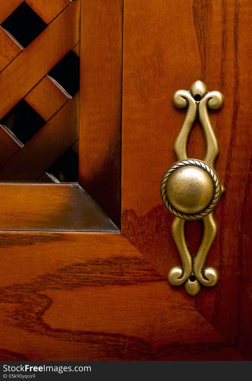 Cupboard wood door. Focus on old-fashioned doorhandle. Cupboard wood door. Focus on old-fashioned doorhandle.