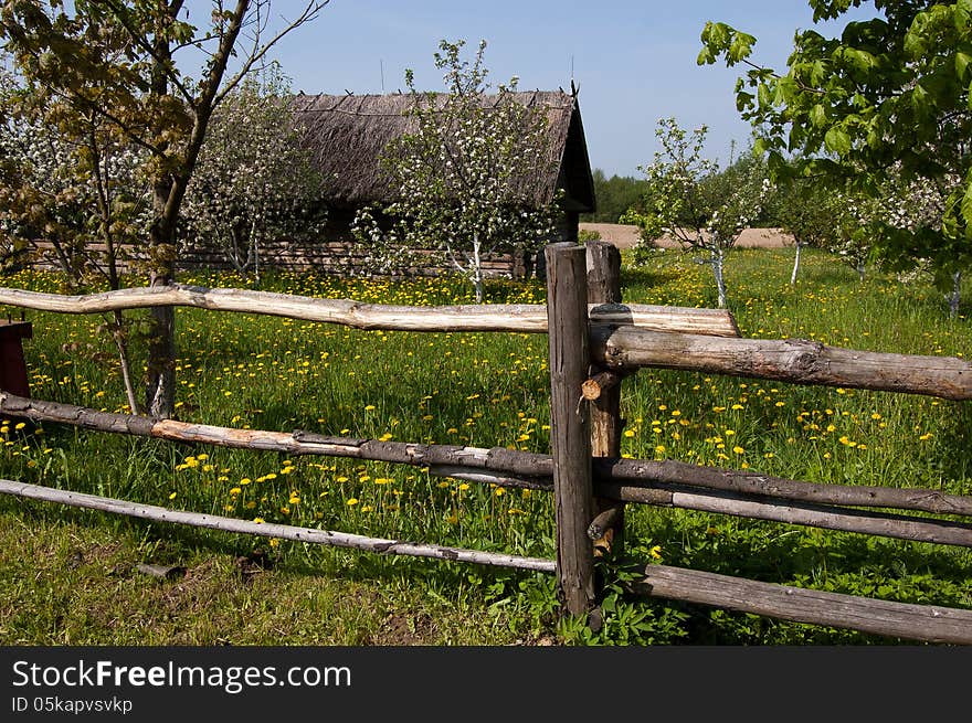 A wooden fence near the old village house. Belarusian wooden architecture of the 19th century. A wooden fence near the old village house. Belarusian wooden architecture of the 19th century.