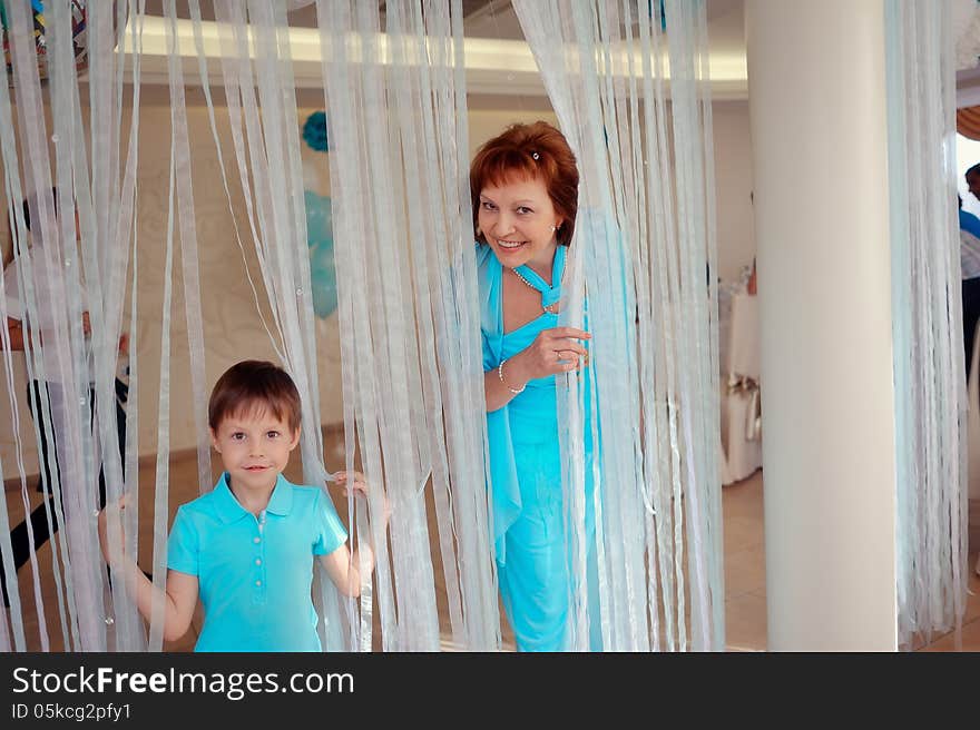 Cheerful family in a blue suit on a background of snowy curtains. Cheerful family in a blue suit on a background of snowy curtains