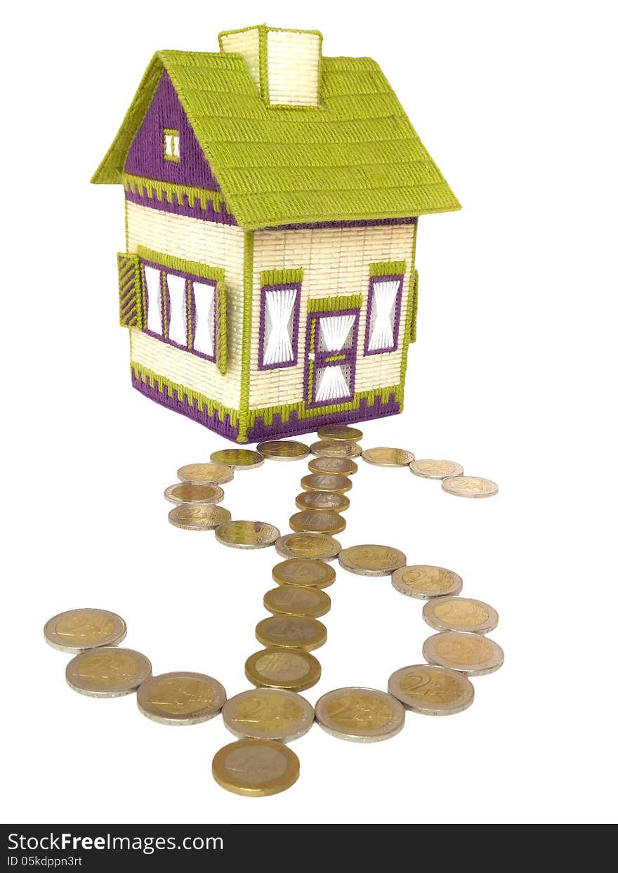 An embroidered house has a path leading to the door made of euro coins and forming the dollar symbol. An embroidered house has a path leading to the door made of euro coins and forming the dollar symbol