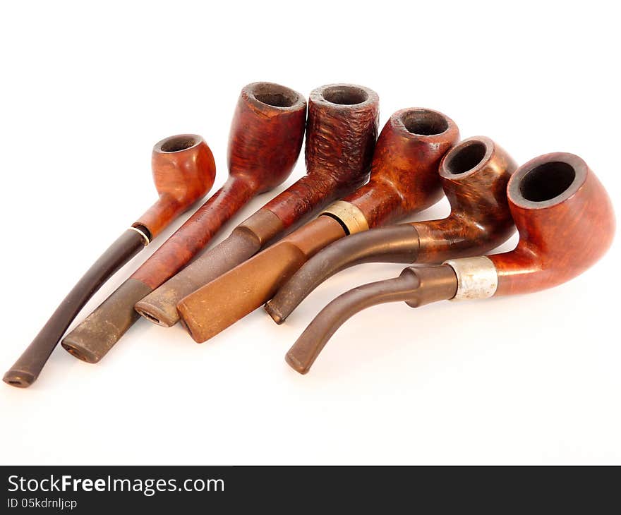 Six smoking pipes lying together isolated on white