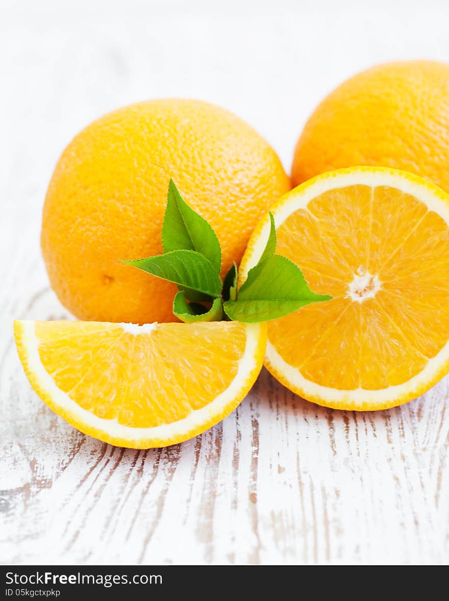 Oranges with leaves on a wooden background