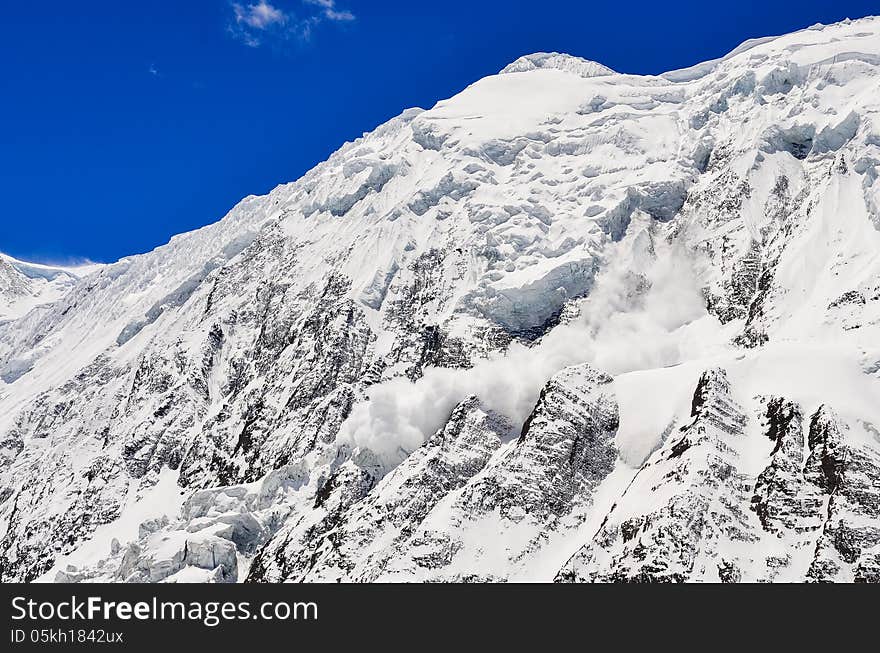 Avalance falling from snowy frozen mountain peak with glacier. Avalance falling from snowy frozen mountain peak with glacier