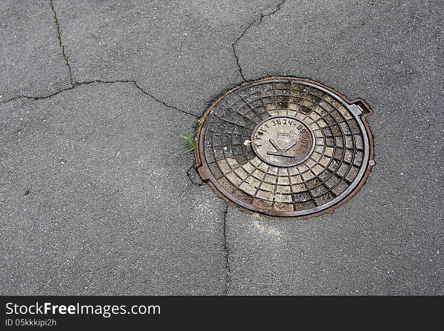 Sewer manhole cover on asphalt. Sewer manhole cover on asphalt