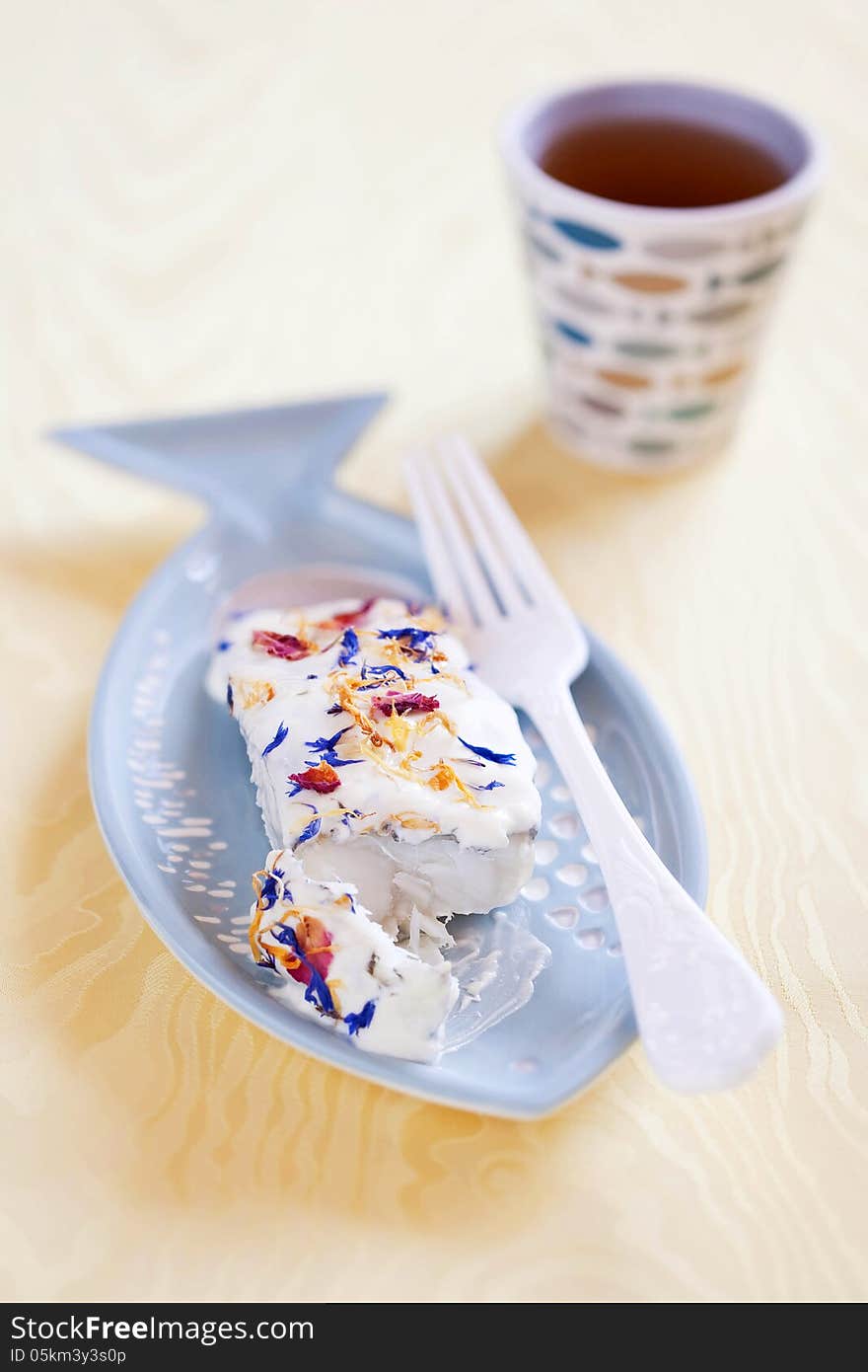 Baked cod with horseradish sauce and dried flower petals, selective focus