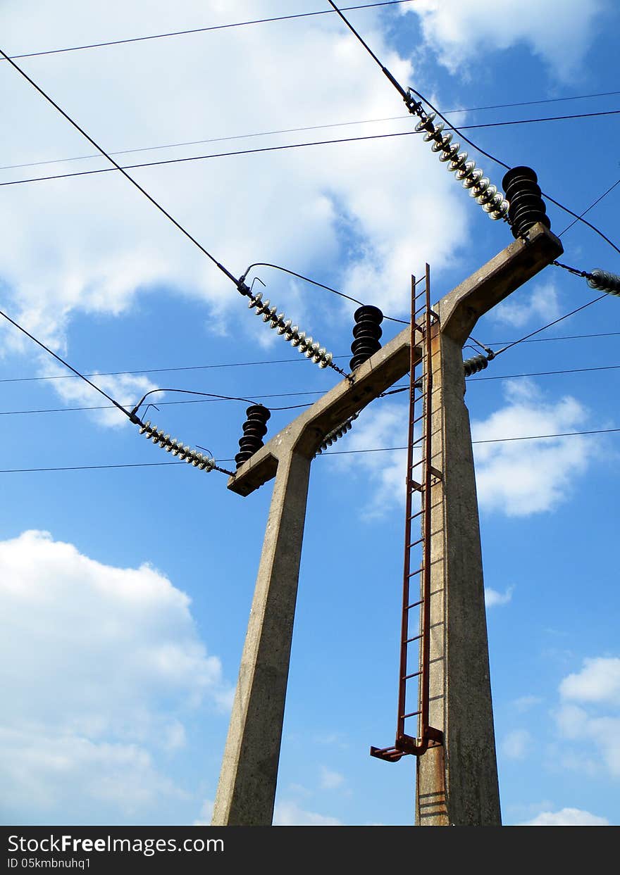 Triple concrete portal electricity pylon located next to a small rural sub station. Triple concrete portal electricity pylon located next to a small rural sub station