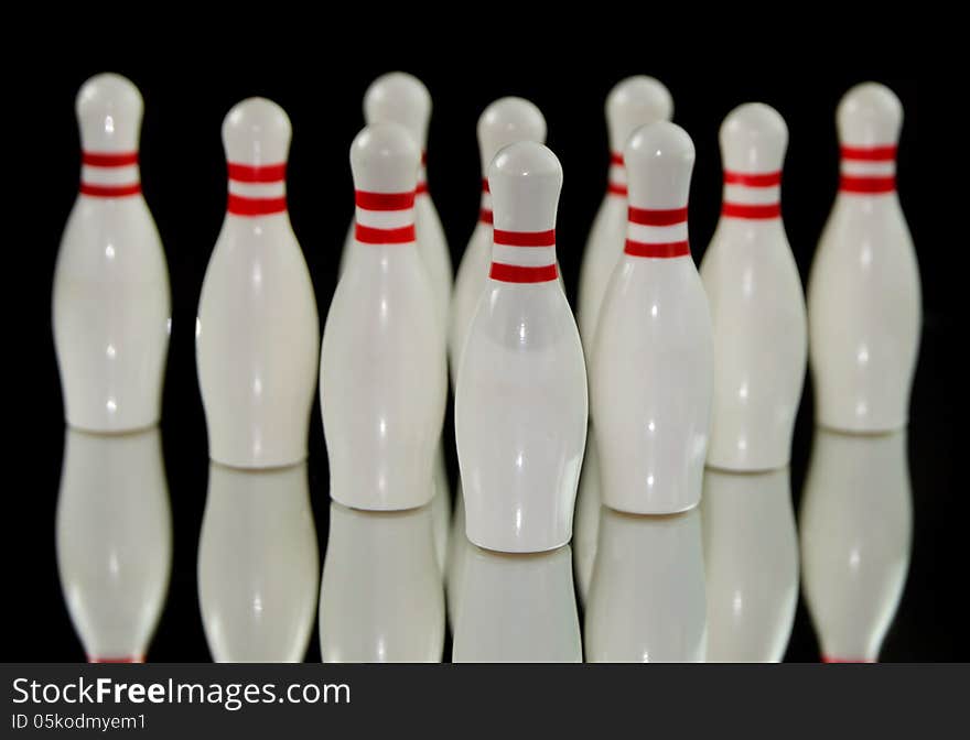 Ten bowling pins isolated on black background