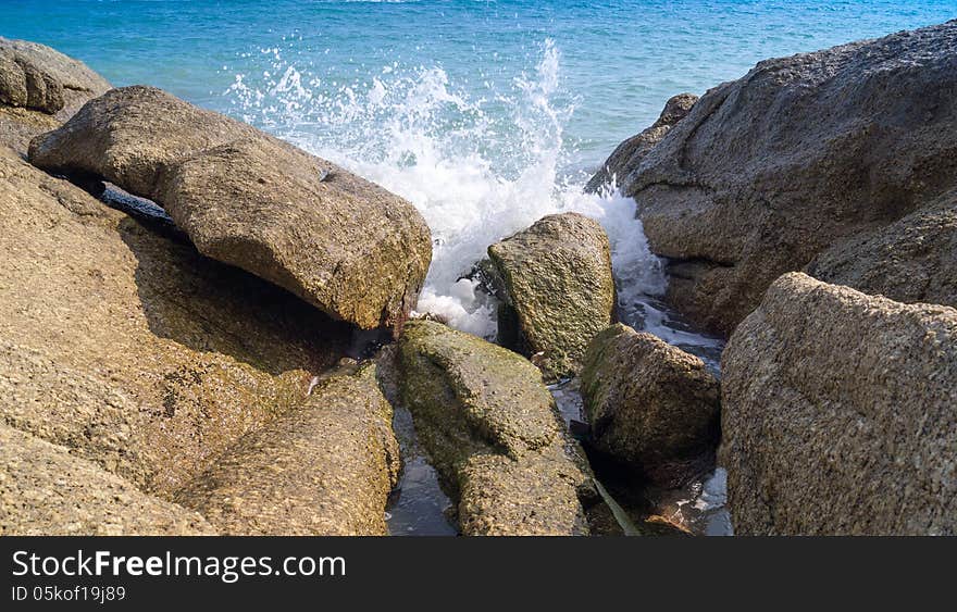 The waves break on the rocks