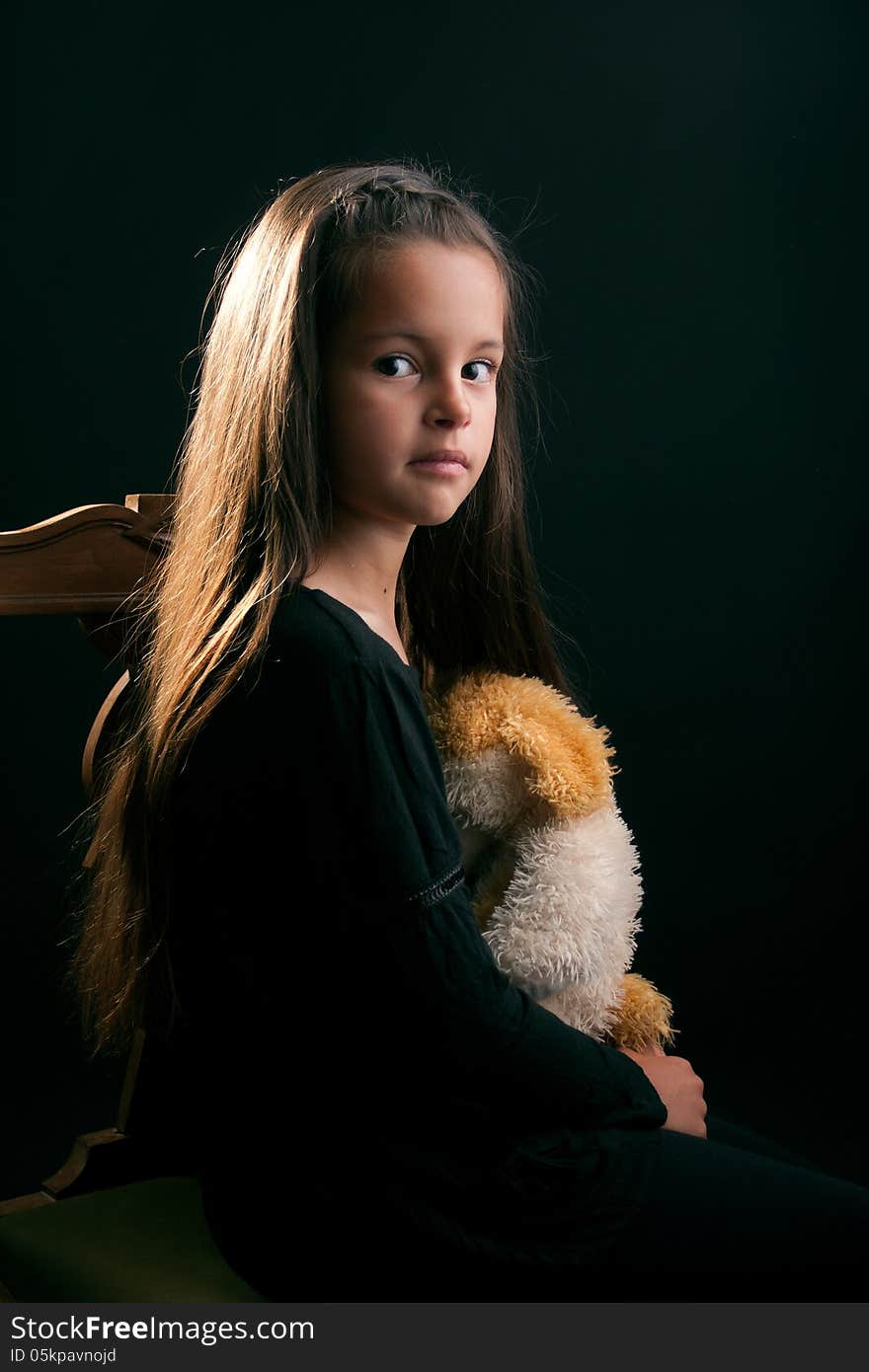 A portrait of a little girl with toy in a casual pose. A portrait of a little girl with toy in a casual pose.