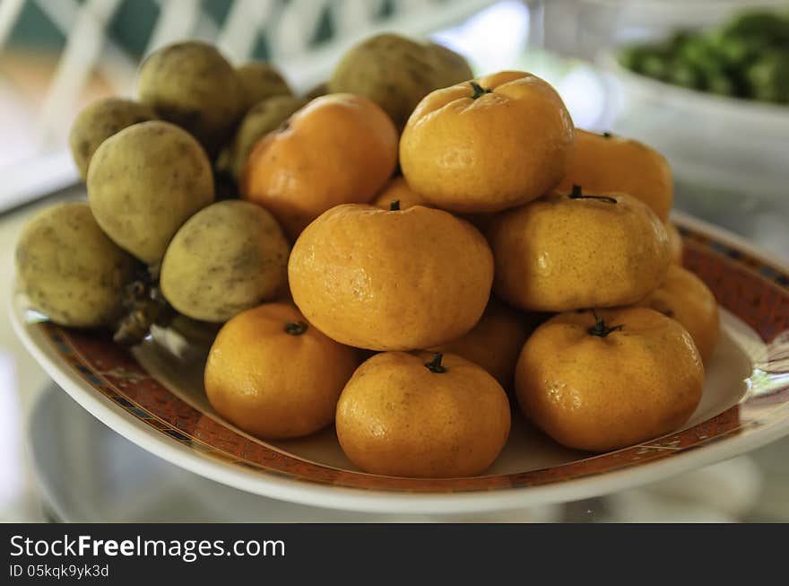 Orange and langsat on a plate in the restaurant