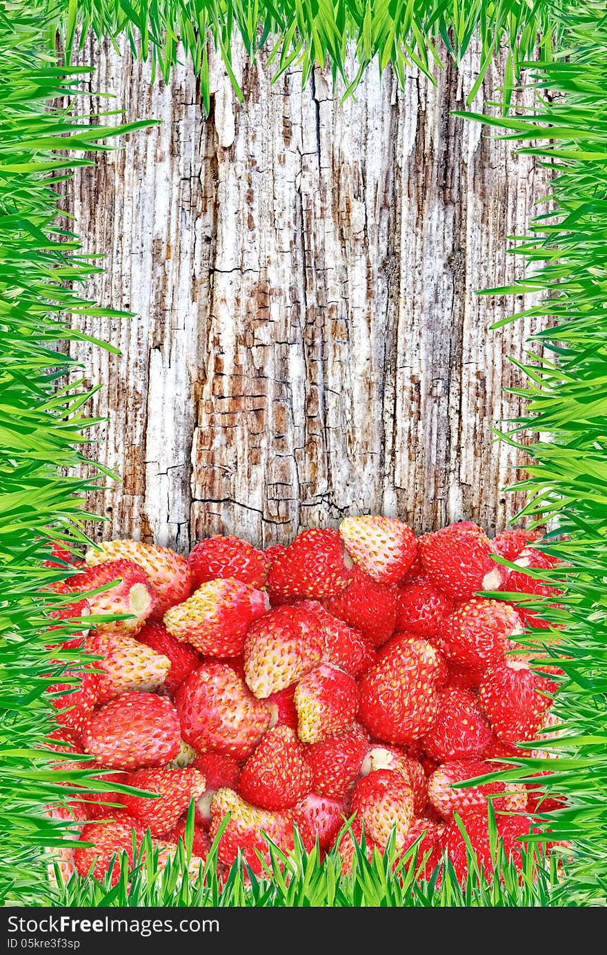 Strawberry on a wooden background with a frame made of grass.