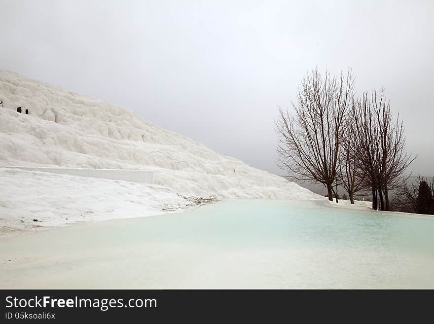 Travertines with blue water in Pamukkale, Turkey