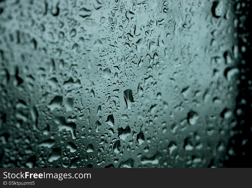 Wet drops of moisture on the glass dark background. Wet drops of moisture on the glass dark background