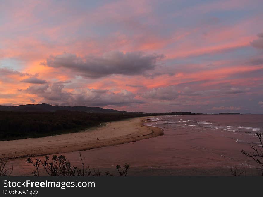 The pink sky of sunset where Boambee Creek meets the Pacific Ocean near Coffs Harbour, NSW. The pink sky of sunset where Boambee Creek meets the Pacific Ocean near Coffs Harbour, NSW