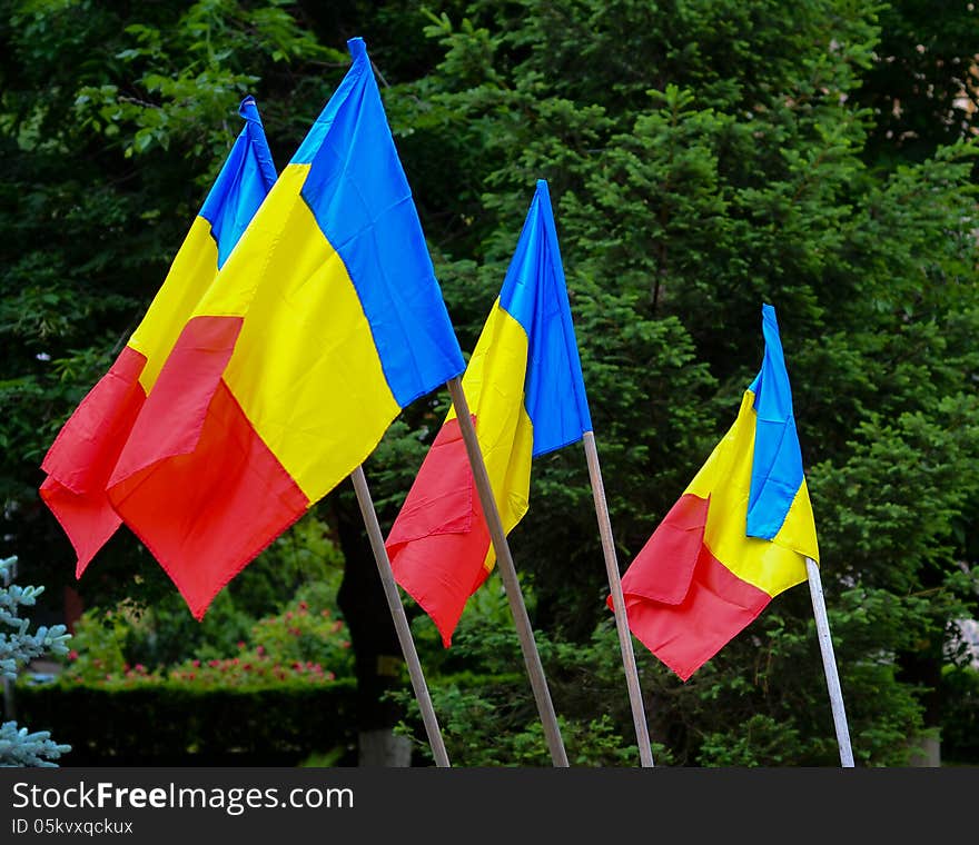 Romanian flags against green trees