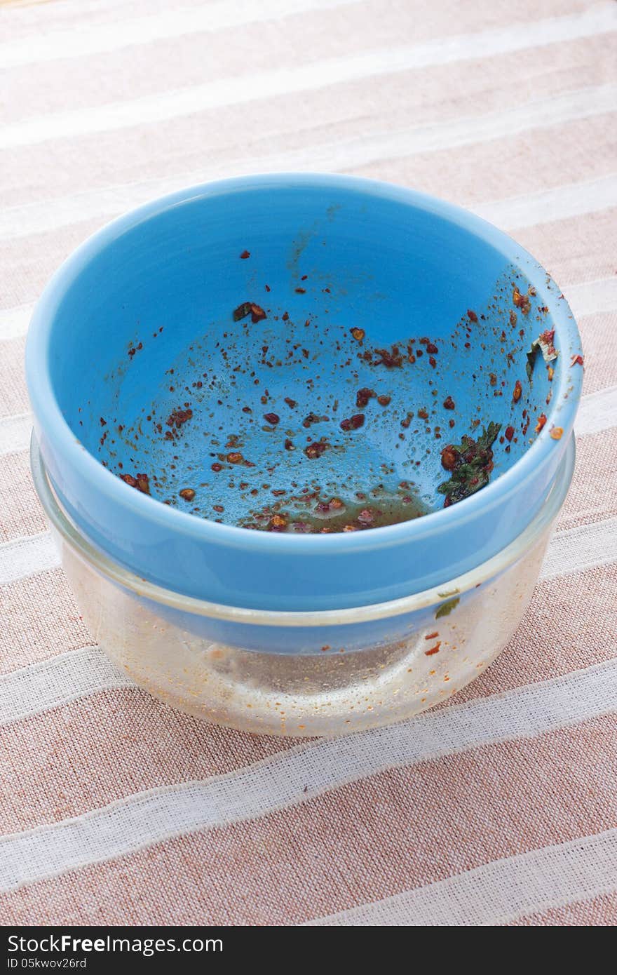 The remains of a plate of ravioli with fork on a blue plate. The remains of a plate of ravioli with fork on a blue plate.