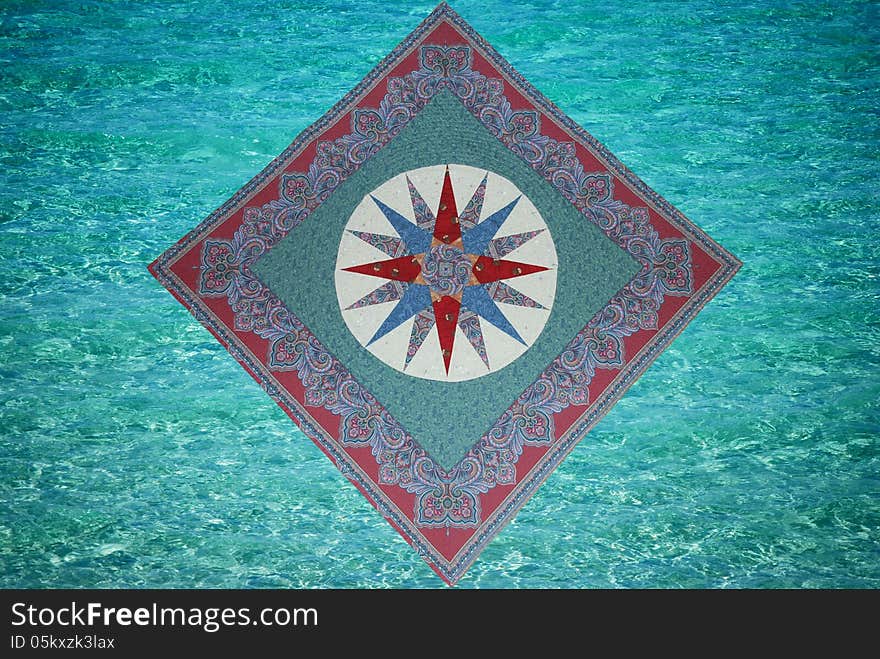 A quilt wall hanging called Mariner’s compass which looks like it is floating on top of the ocean waves. A quilt wall hanging called Mariner’s compass which looks like it is floating on top of the ocean waves