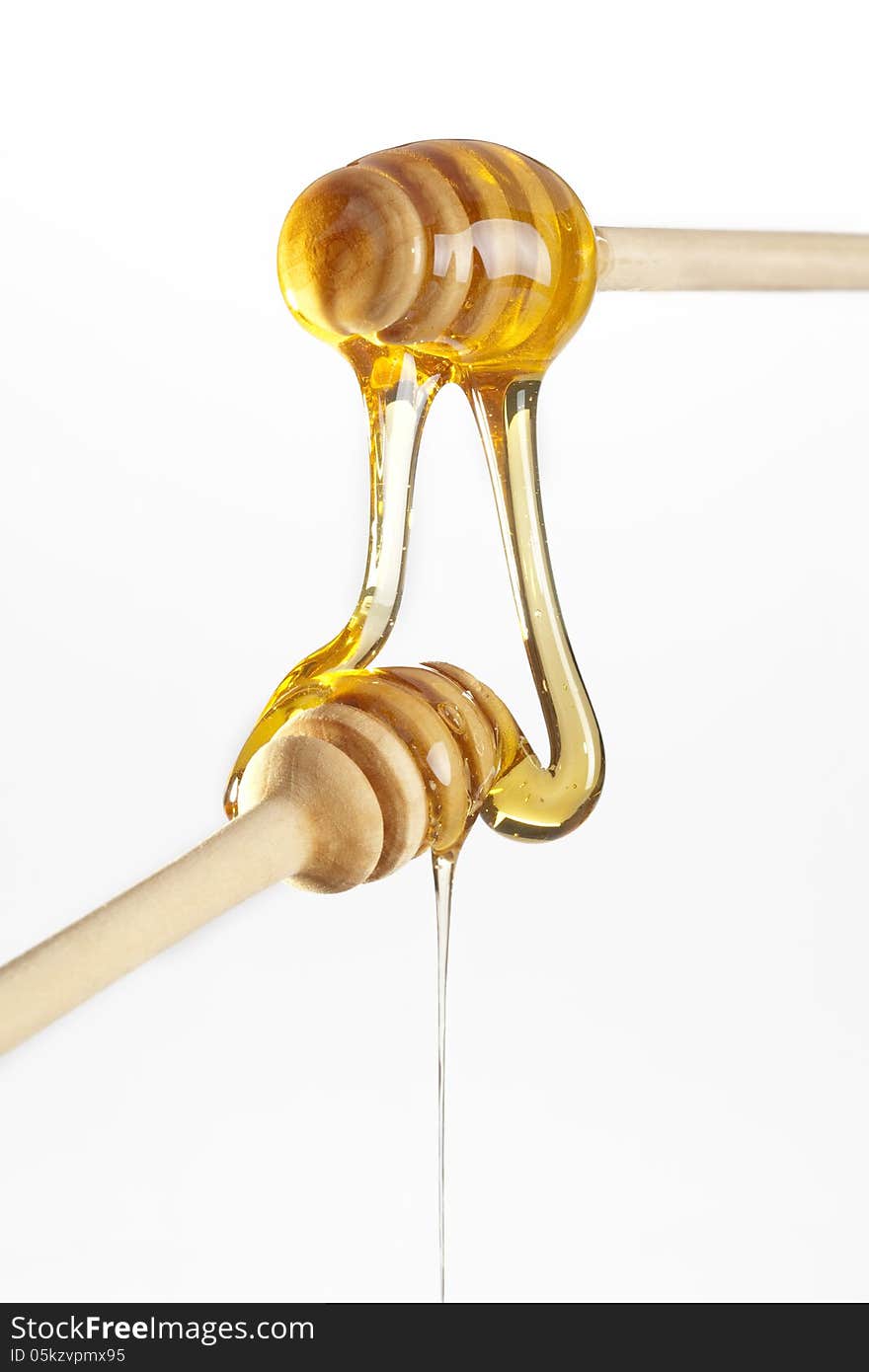 Honey dripping from a wooden honey dippers