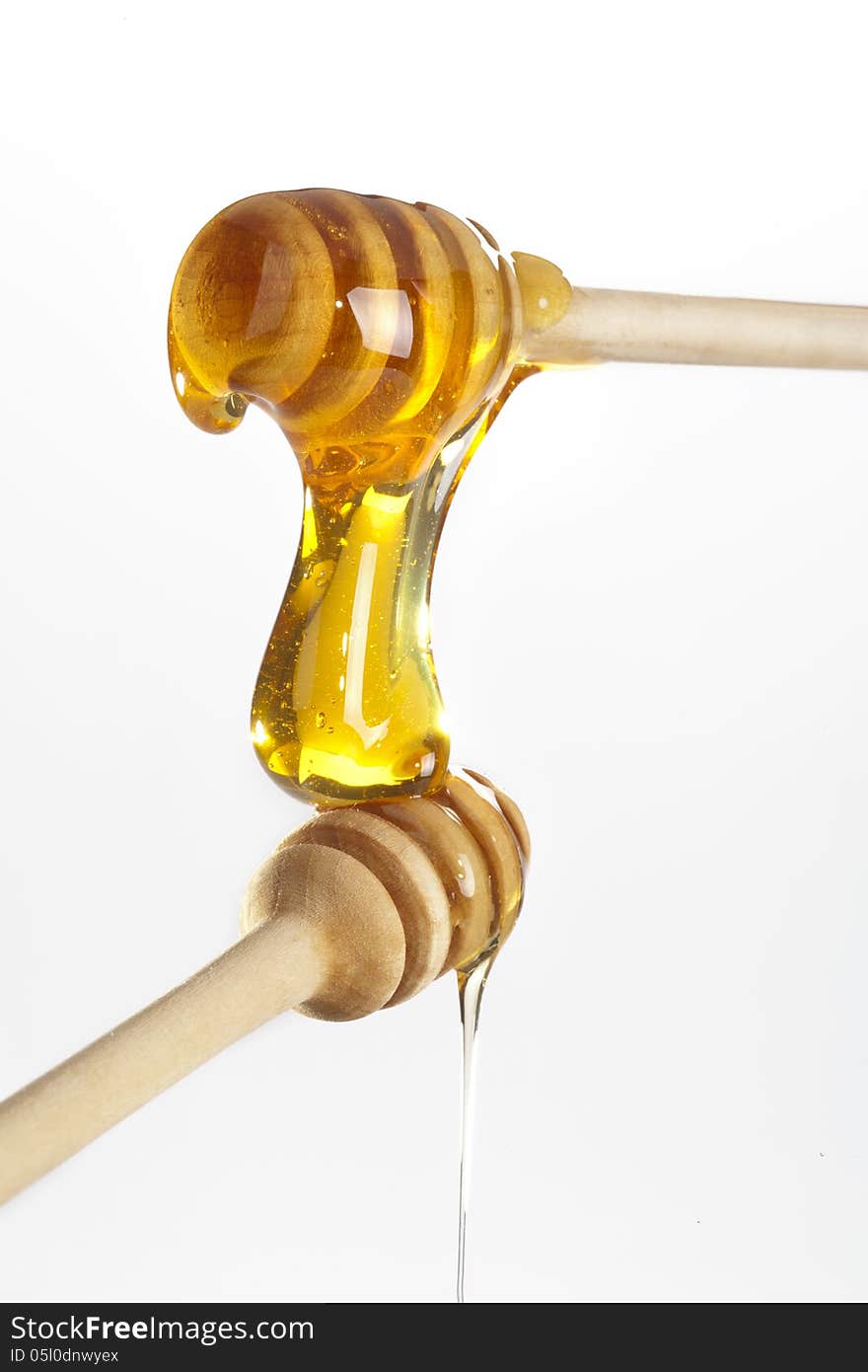 Honey dripping from a wooden honey dippers