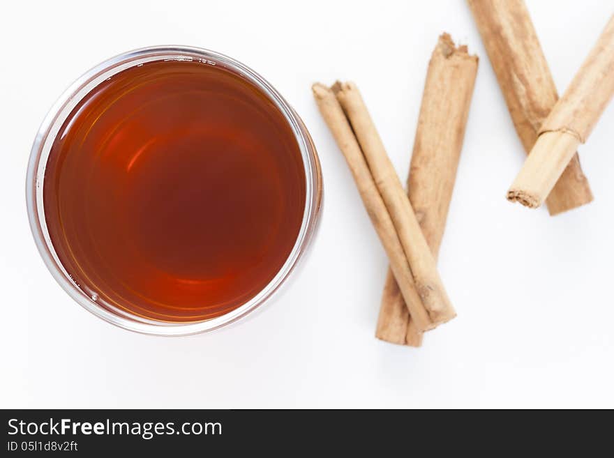 Cup of red tea with cinnamon isolated on white background.