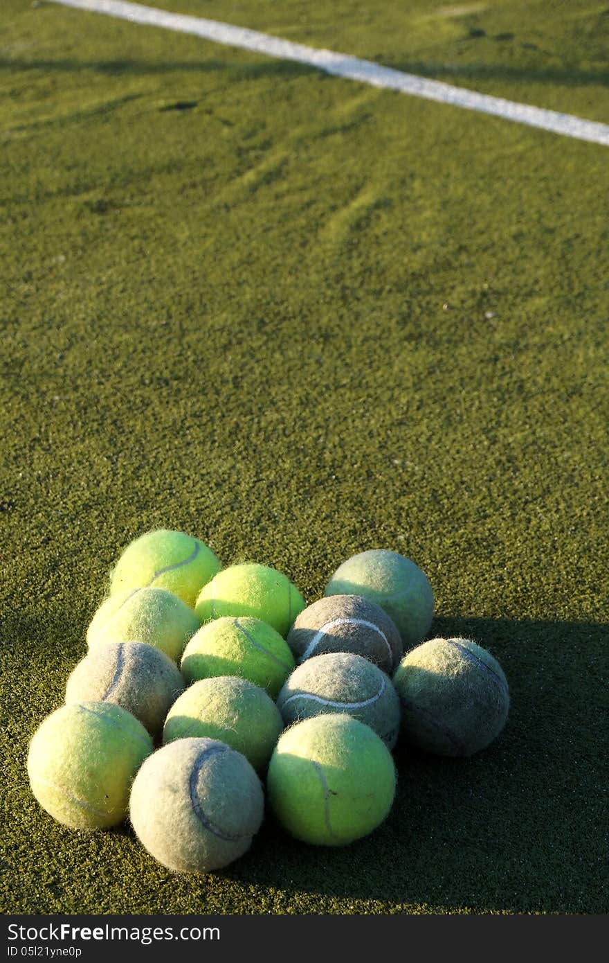 Group Of Tennis Balls In Front Of White Line On Court