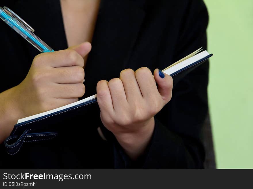 Businesswoman writing in notebook