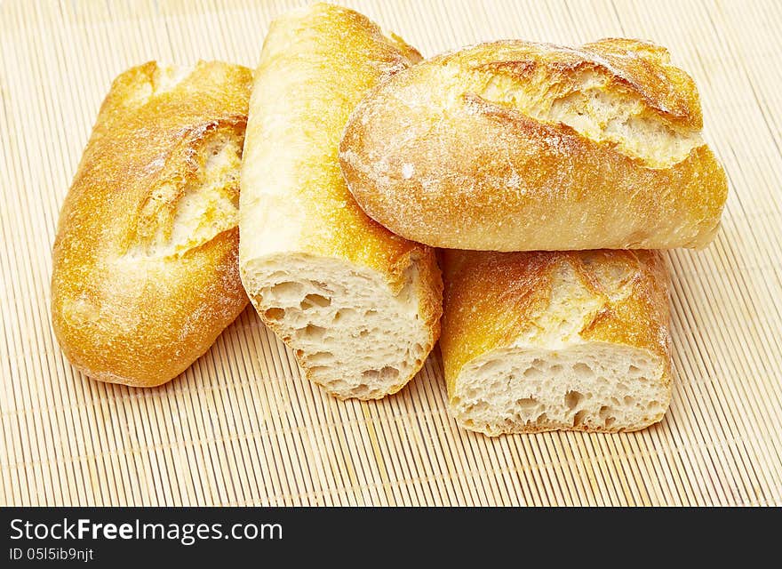 Fresh Crusty the cut baguettes on a wooden background.