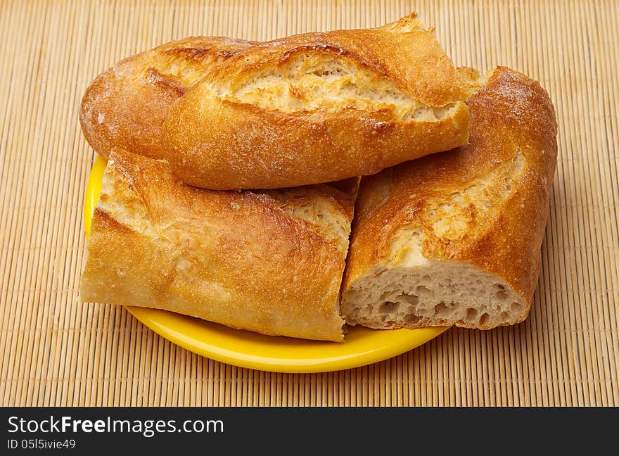 Fresh Crusty the cut baguettes on a wooden background.