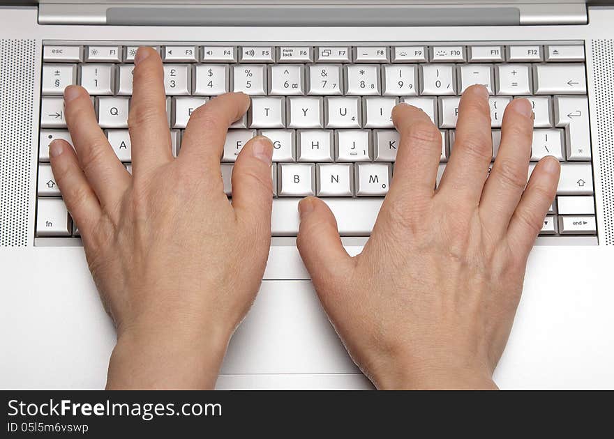 Female hands printing on the keypad a laptop