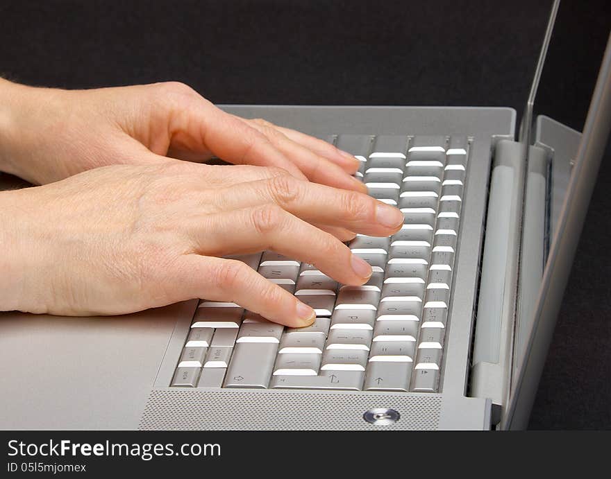 Female hands printing on the keypad a laptop