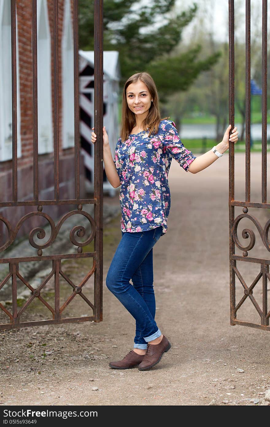 Full-length portrait of a beautiful girl with a fence