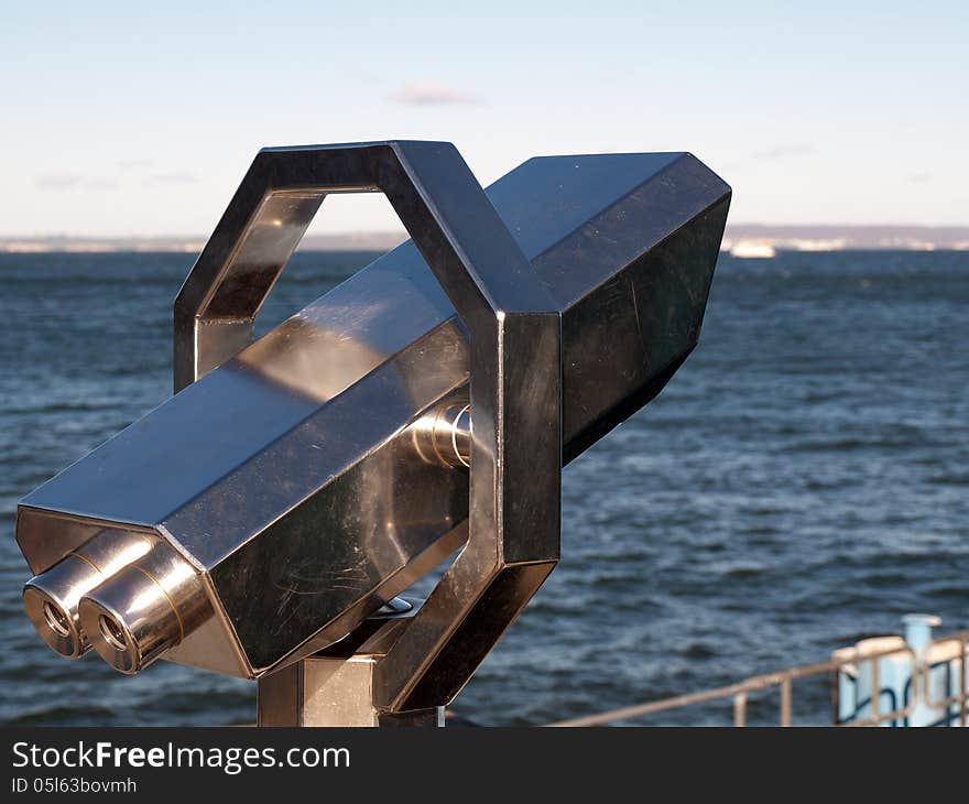 Telescope by the sea with blue sky