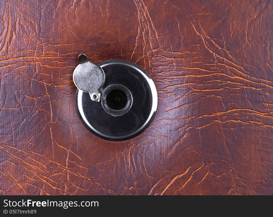 Peephole on a leather door. Horizontal position.