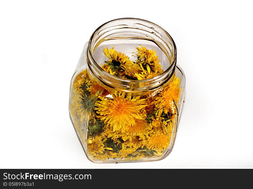 Dandelion jam in a glass jar on a white background