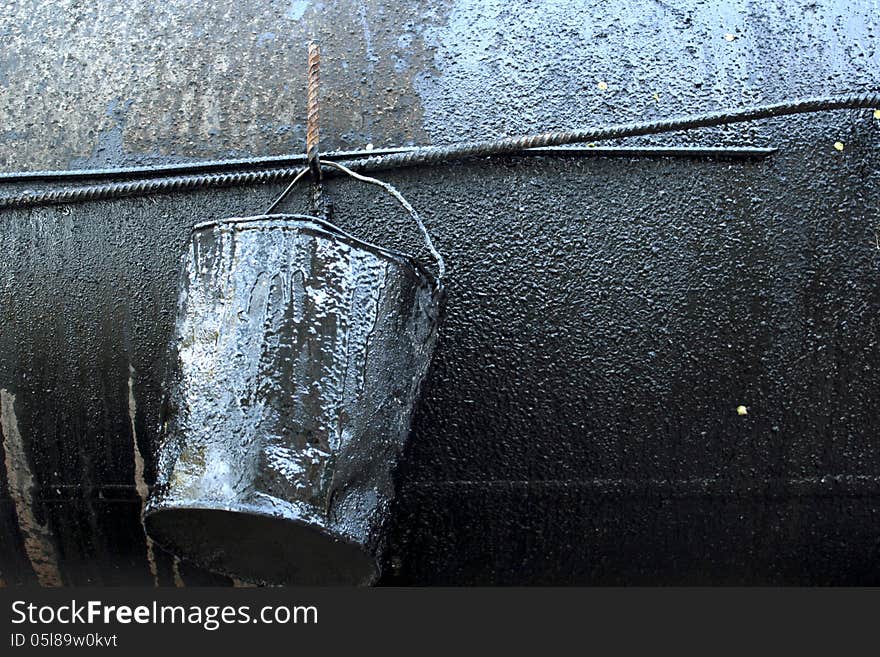 Crumpled, dirty metal bucket, which poured oil