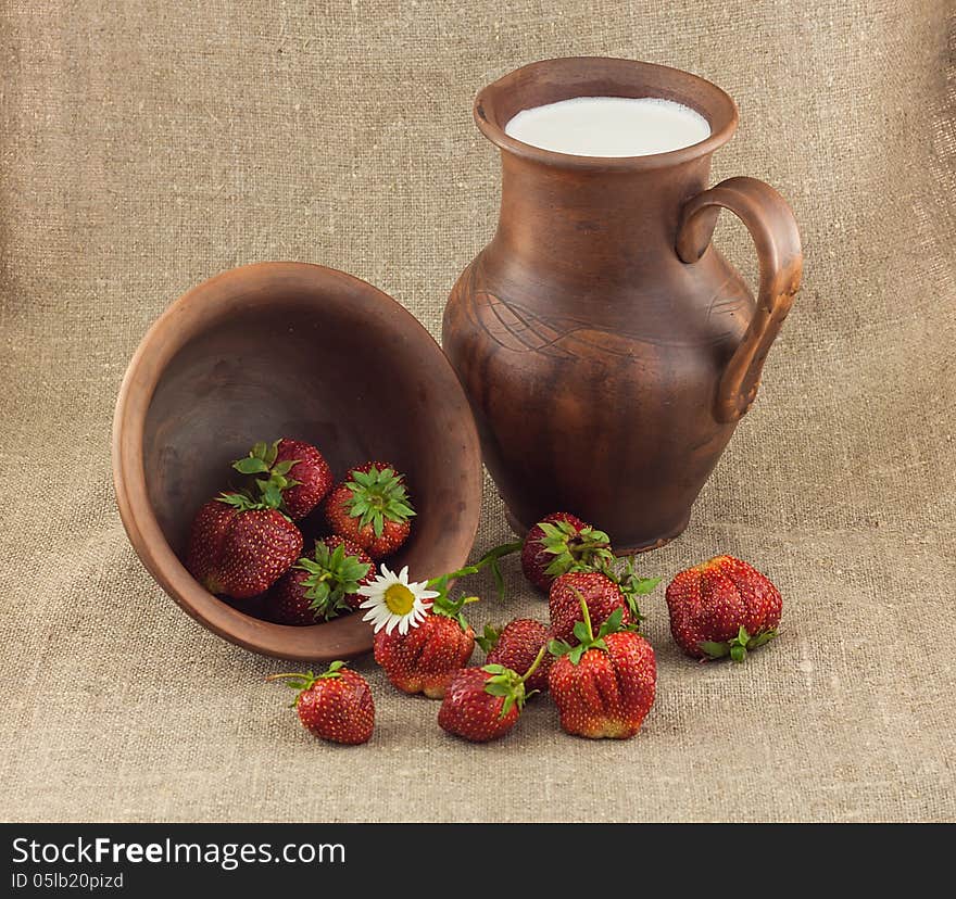 Rustic still life of strawberries in the clay pot