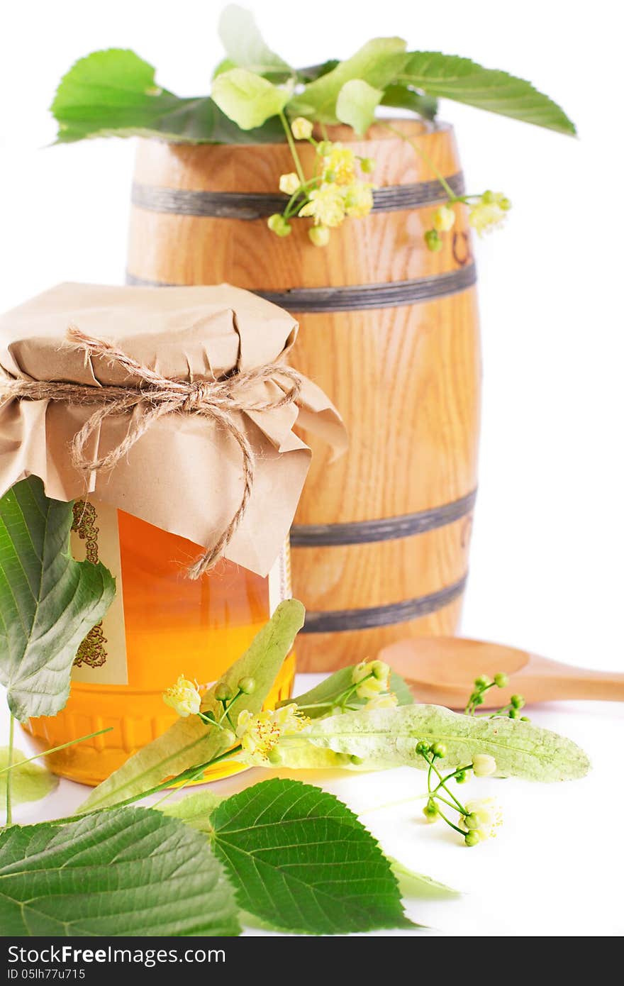 Linden honey jar and barrel with flowers isolated on white