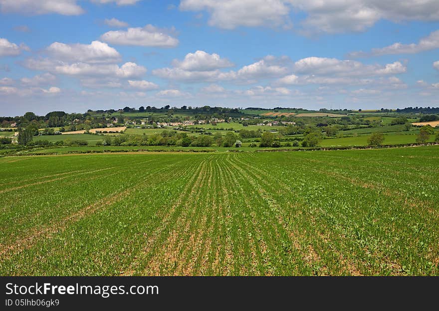 An English Summer Landscape With A Village On A Hill