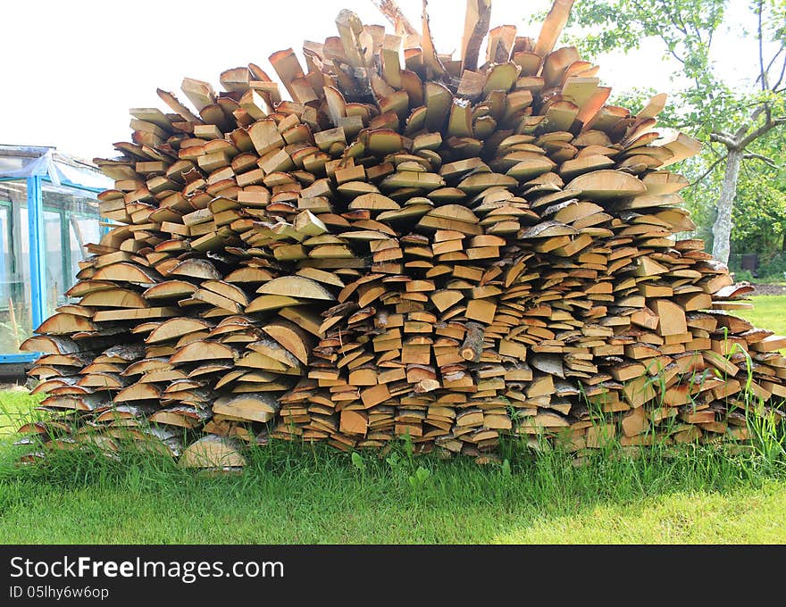 Various wood firewood stacked in a pile. Various wood firewood stacked in a pile