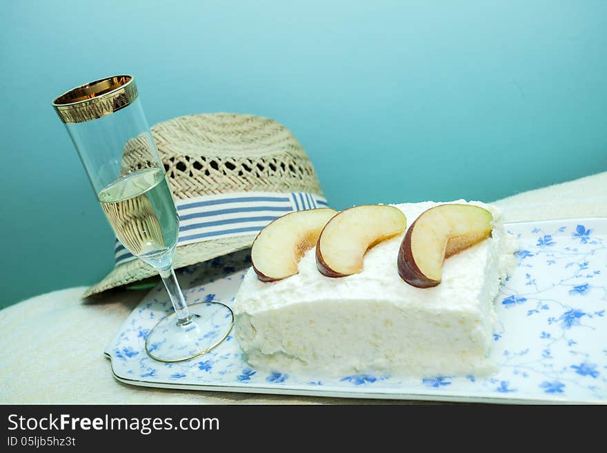 Apple pie with whipped cream, sweet white wine and a man's hat