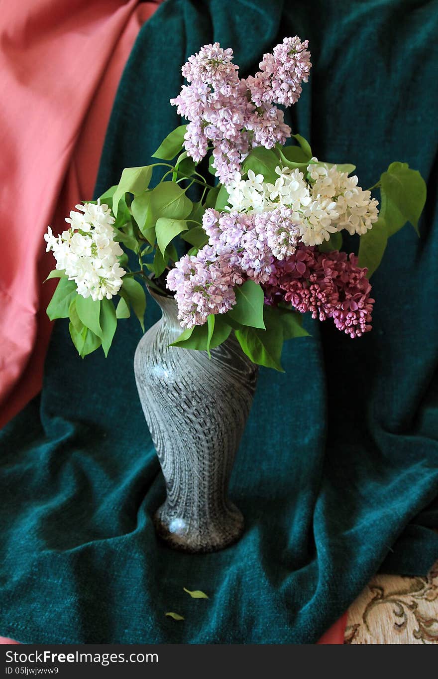 The posy of colorful lilac in the vase. The posy of colorful lilac in the vase